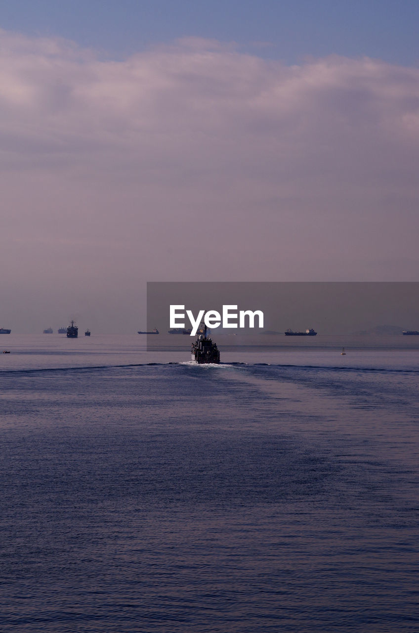 SILHOUETTE BOAT SAILING IN SEA AGAINST SKY DURING SUNSET