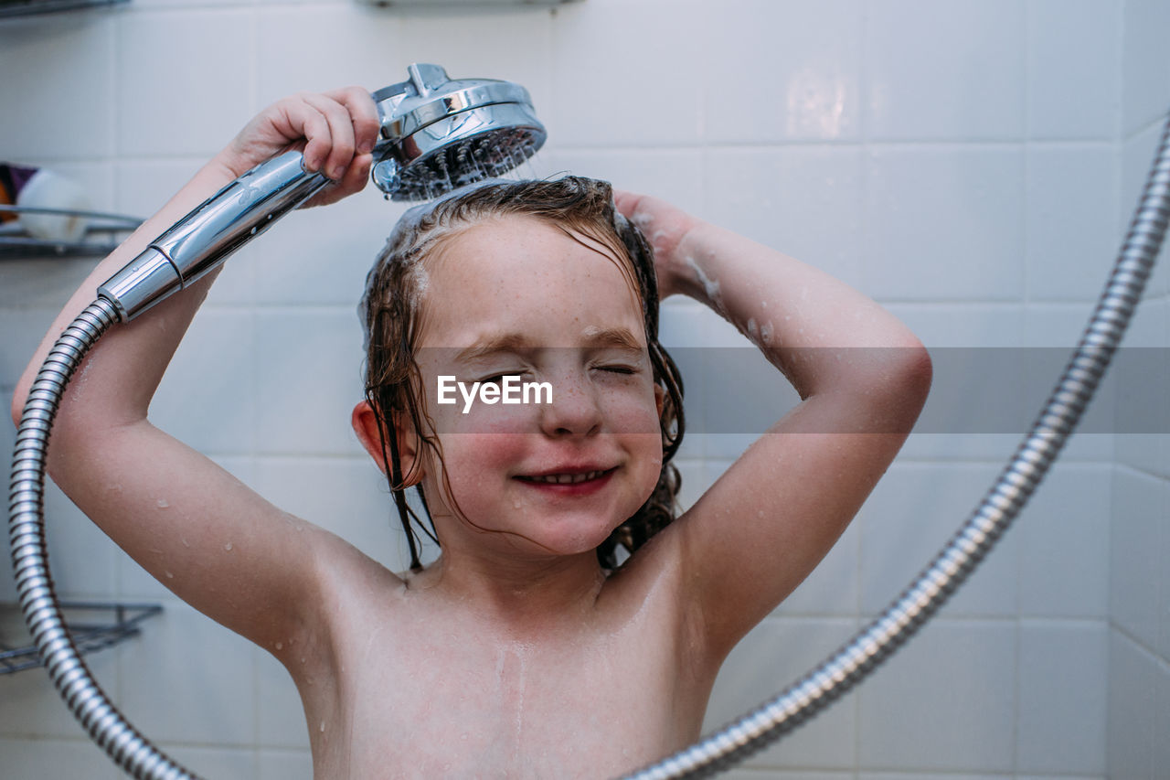 Close up of child washing hair in the shower