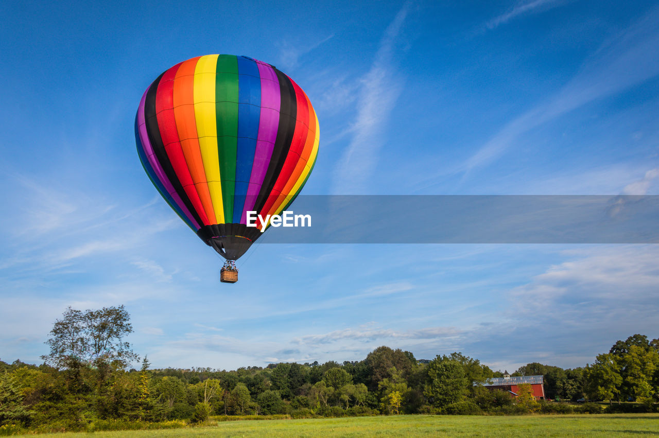 HOT AIR BALLOON FLYING OVER FIELD