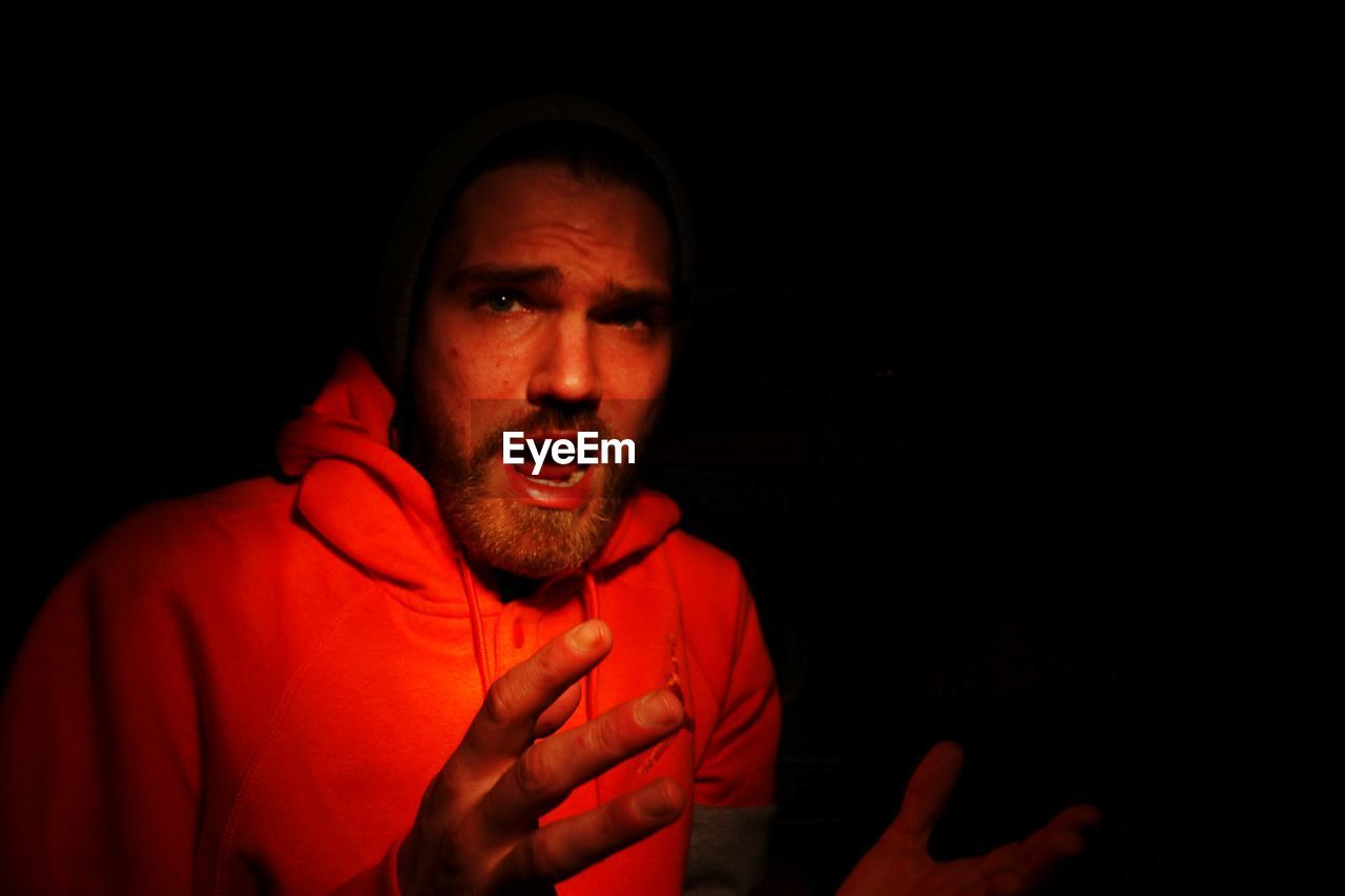 Portrait of surprised man with open mouth in darkroom