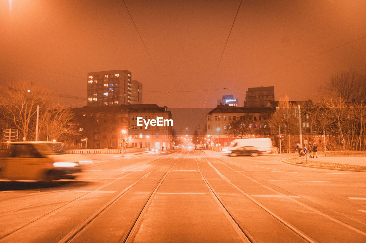 VIEW OF CITY STREET AND BUILDINGS AT NIGHT