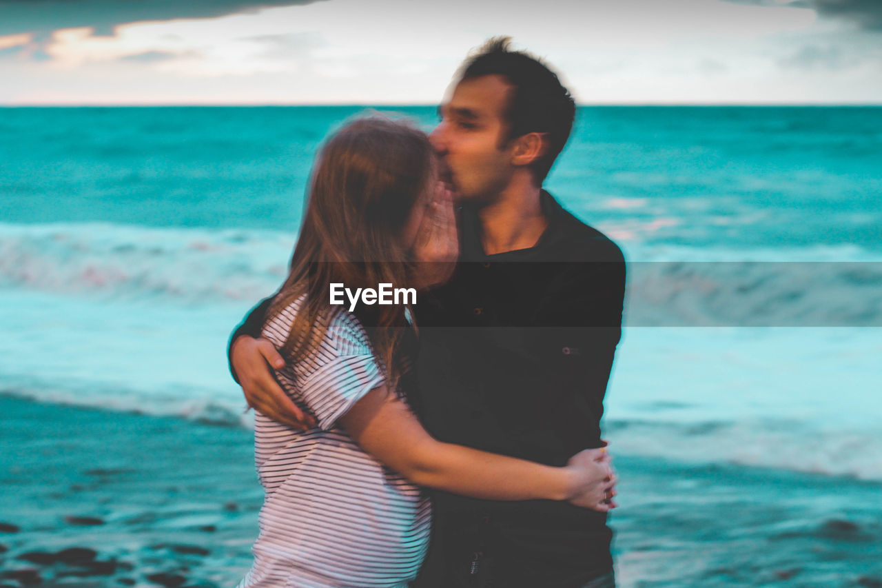 Young couple standing on beach