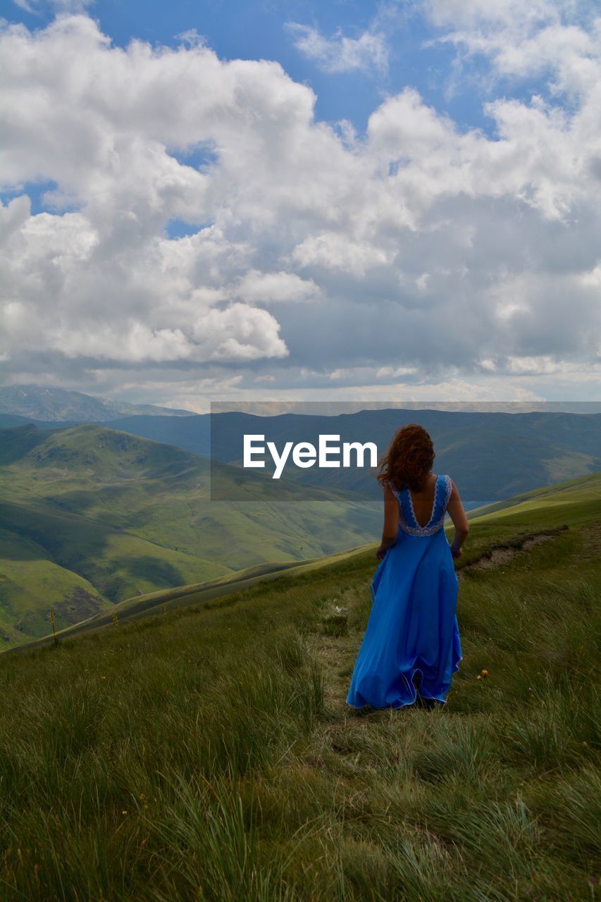 Woman standing on field against sky