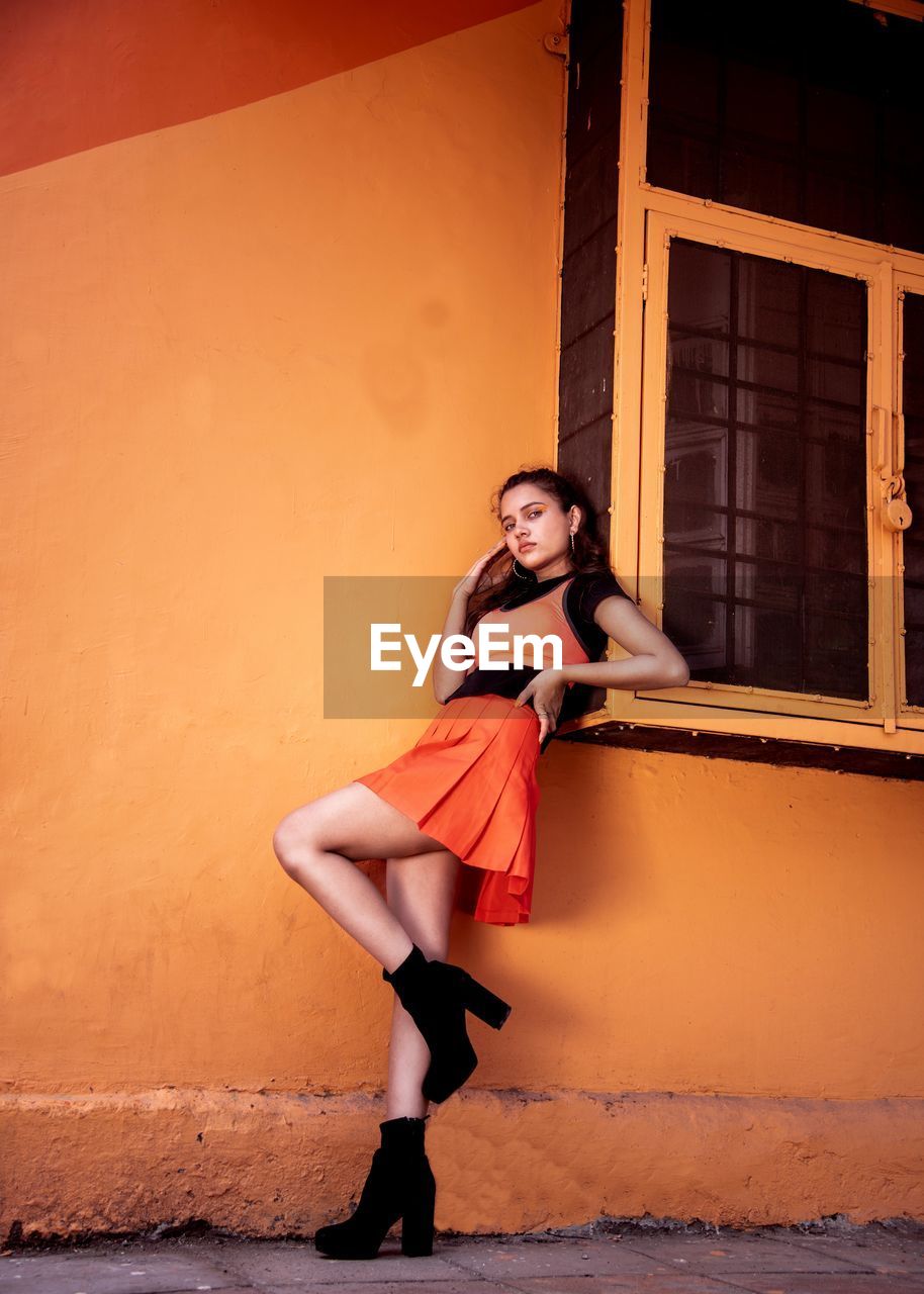 Portrait of woman leaning on wall