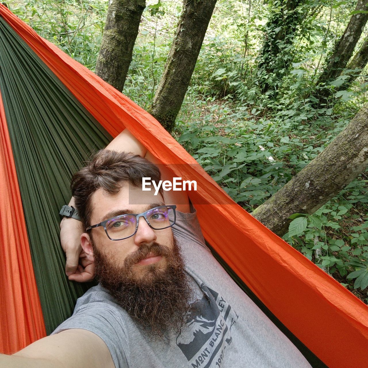 Portrait of young man on amaca against trees