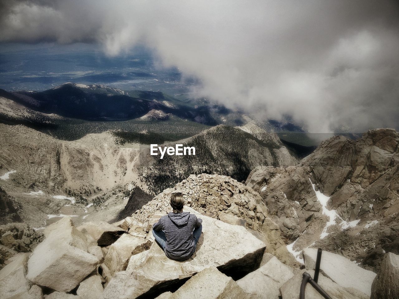 Rear view of woman sitting on mountain