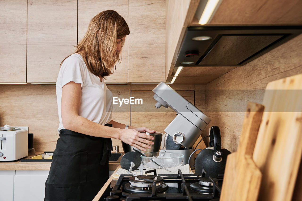 Woman cooking at preparing food, using food processor,