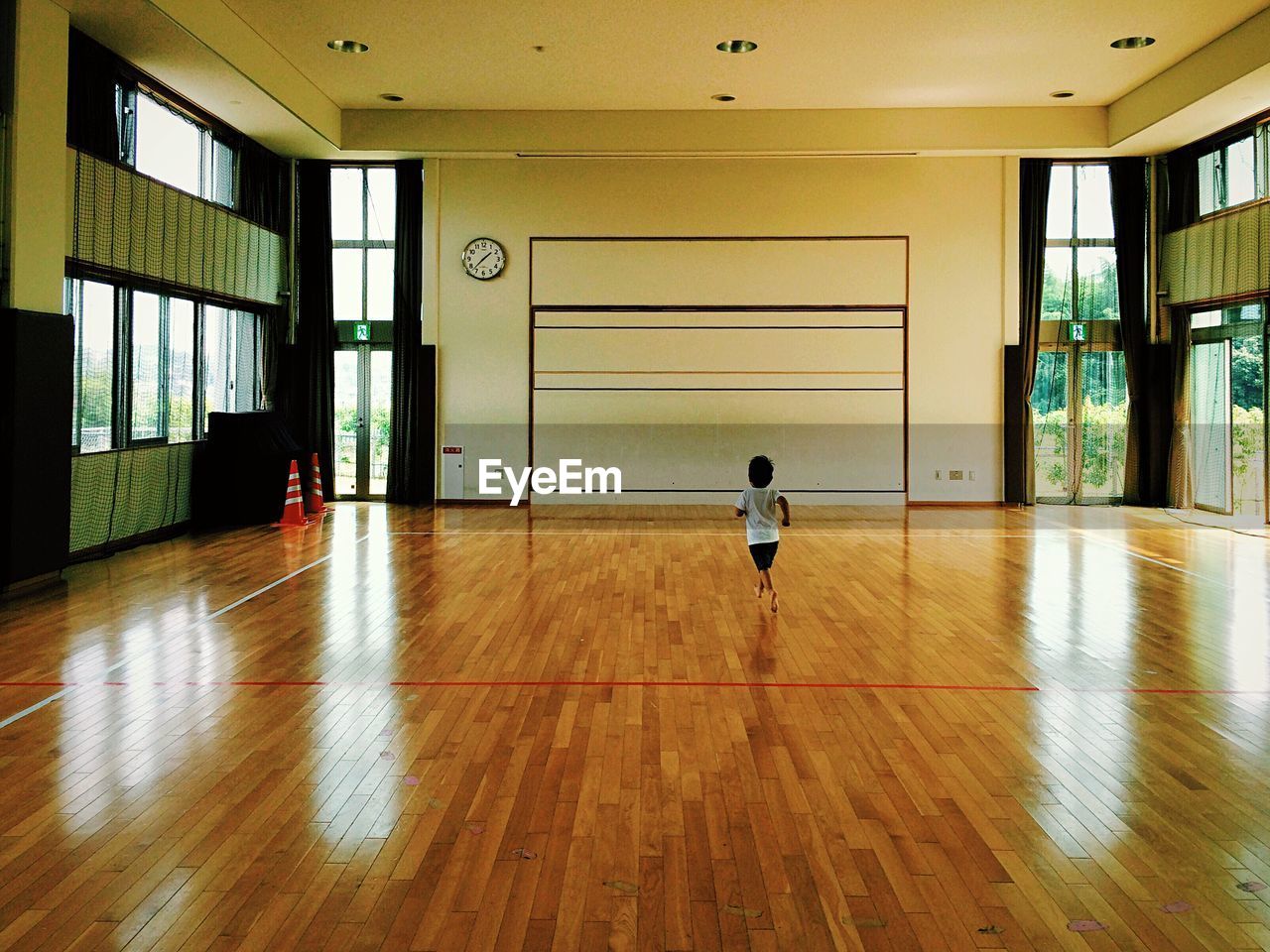 Rear view of boy running on hardwood floor
