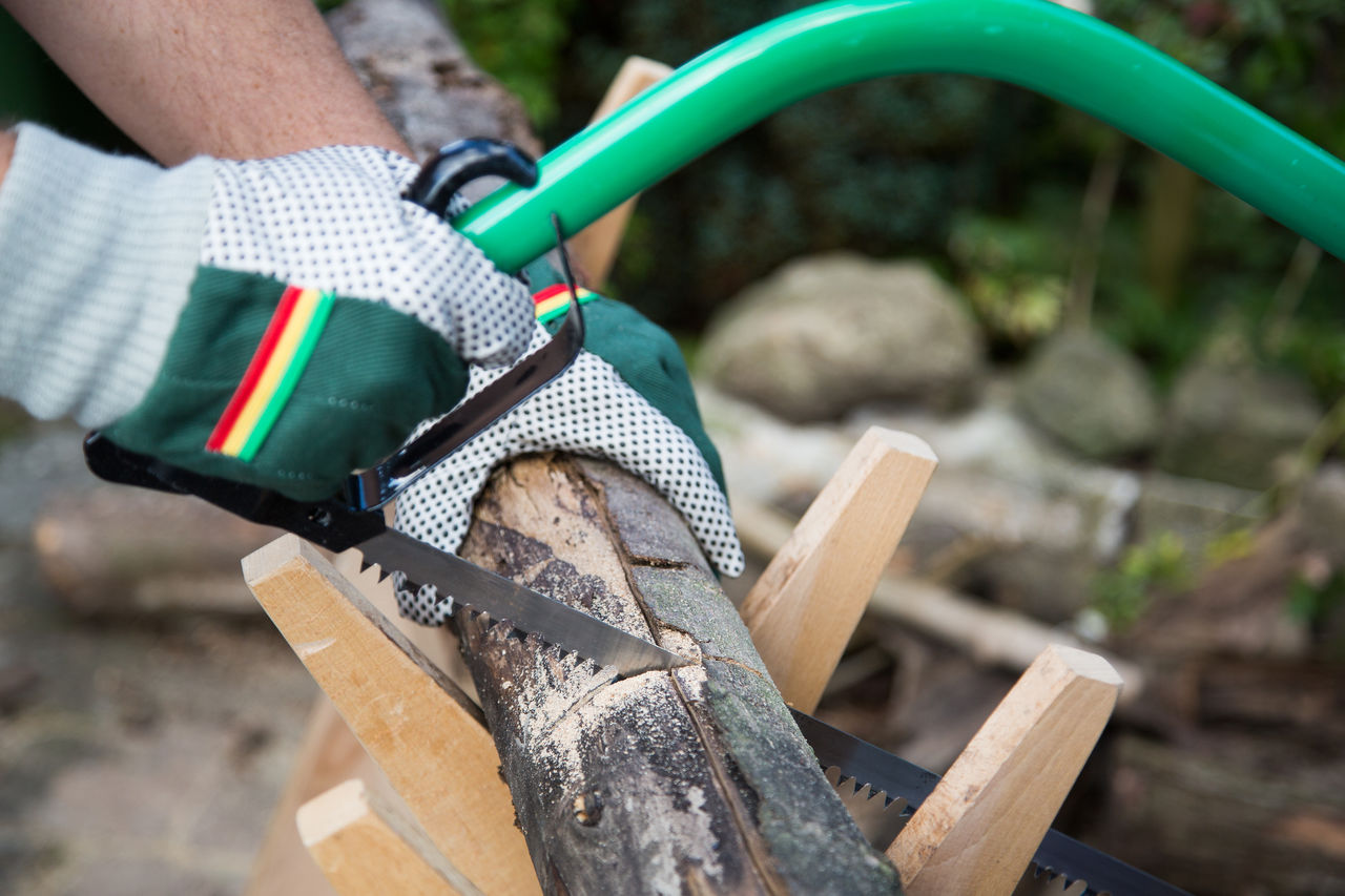 Close-up of hand cutting wood