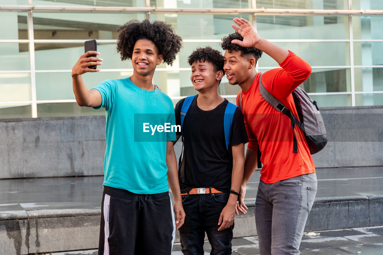 Multiethnic friends taking selfie in the street