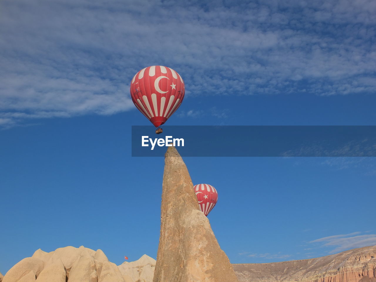 LOW ANGLE VIEW OF HOT AIR BALLOON FLYING OVER LAND