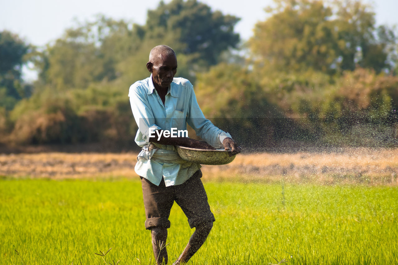 Farmer working while standing on field