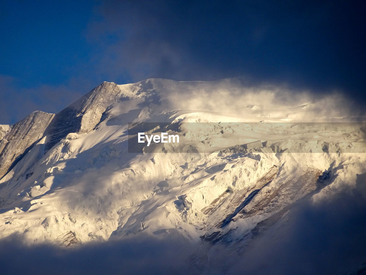 Low angle view of snowcapped mountains against sky