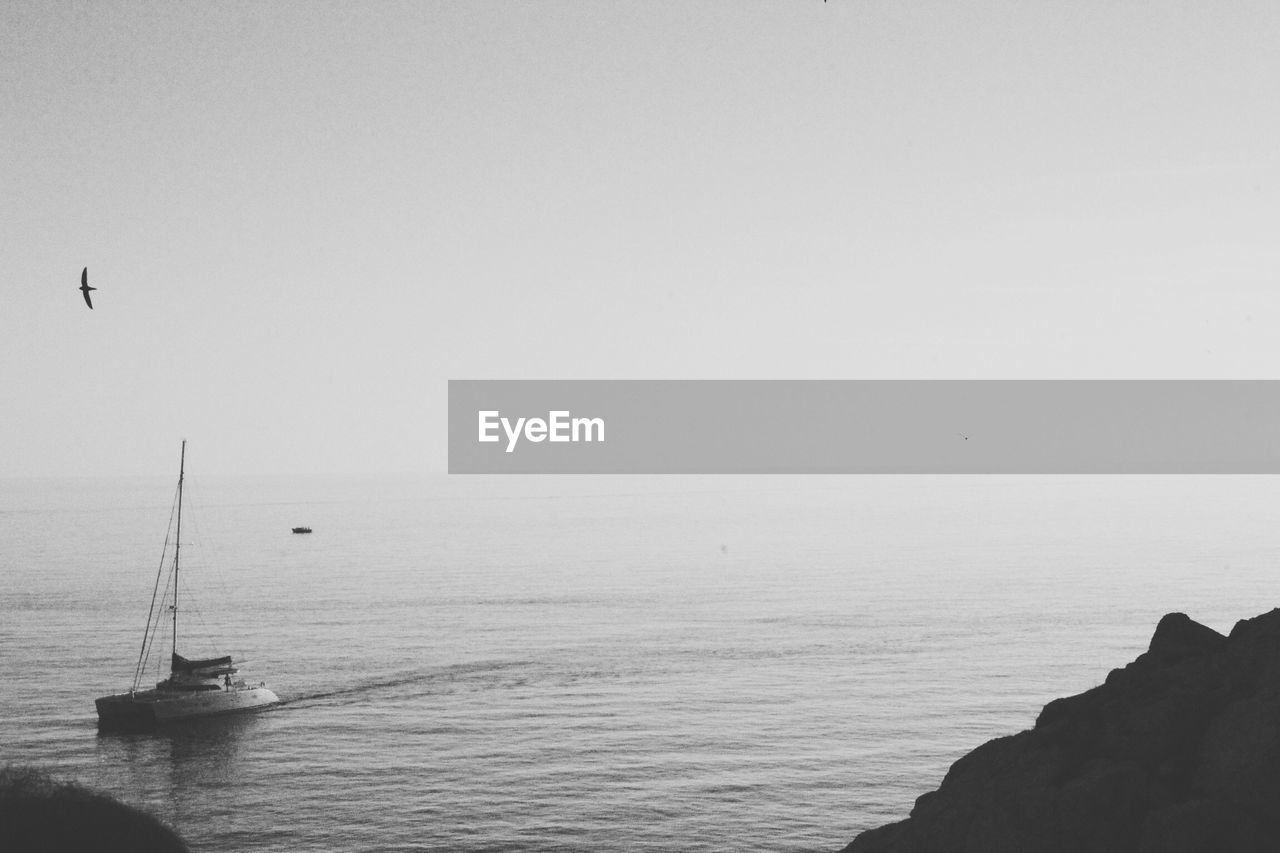 Lone boat in calm sea against clear sky