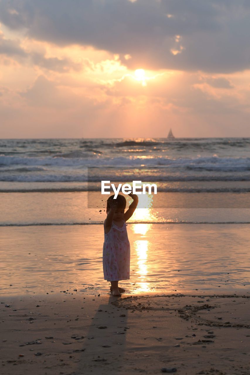 WOMAN ON BEACH DURING SUNSET