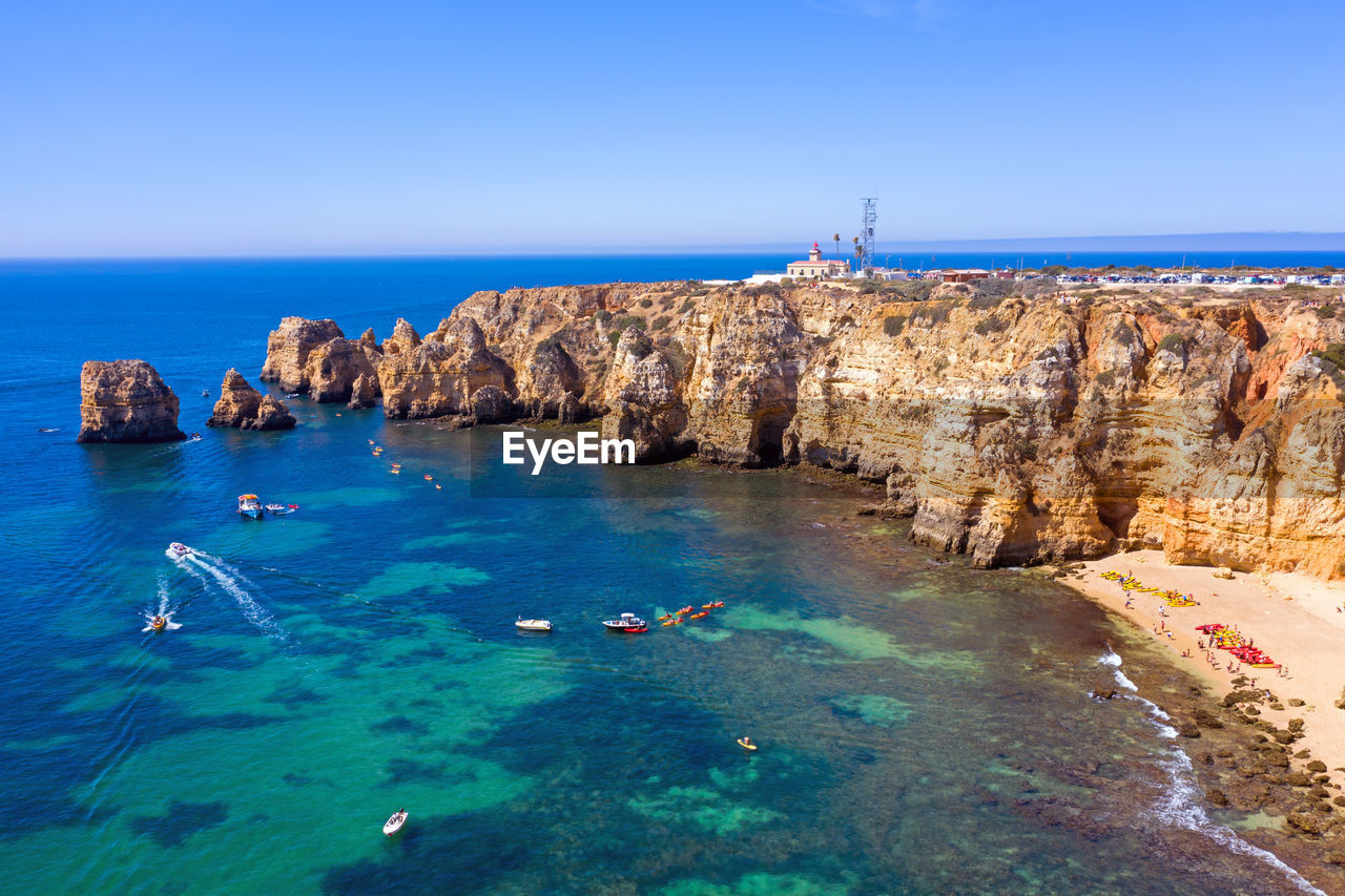 PANORAMIC VIEW OF SEA AND ROCKS AGAINST CLEAR SKY