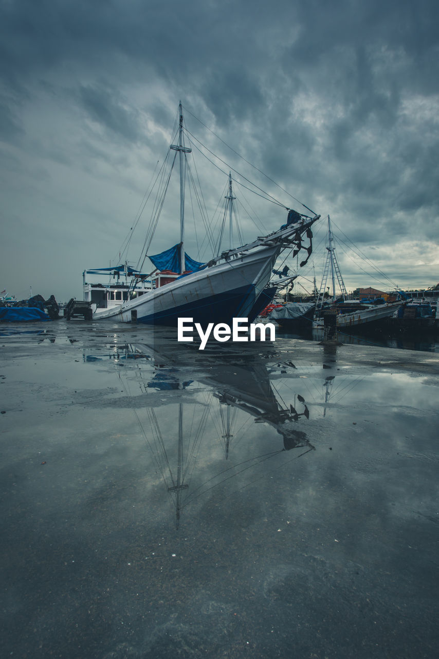 SAILBOAT MOORED IN SEA AGAINST SKY