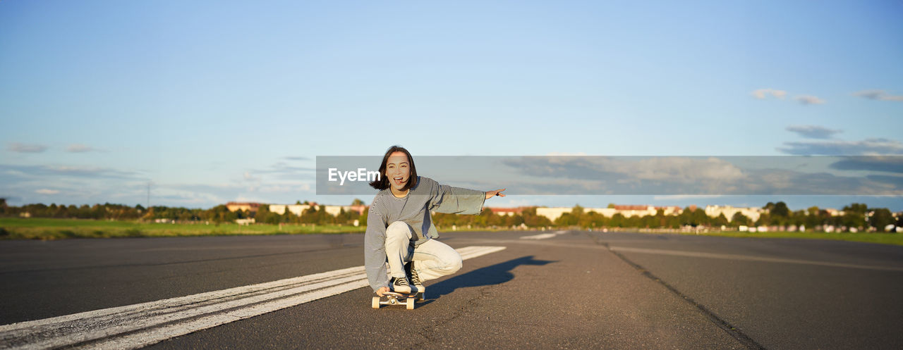 rear view of woman walking on road against clear sky
