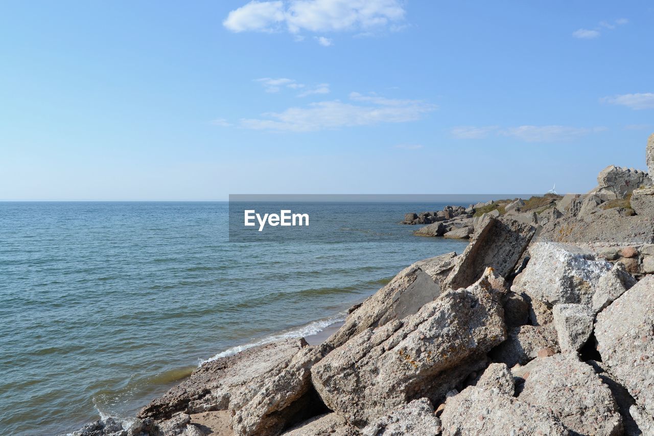 SCENIC VIEW OF ROCKY BEACH AGAINST SKY