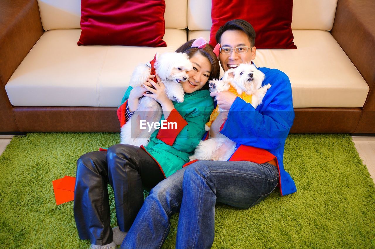 High angle view of man and woman sitting with dogs