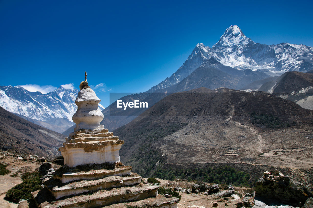 Scenic view of snowcapped mountains against clear blue sky