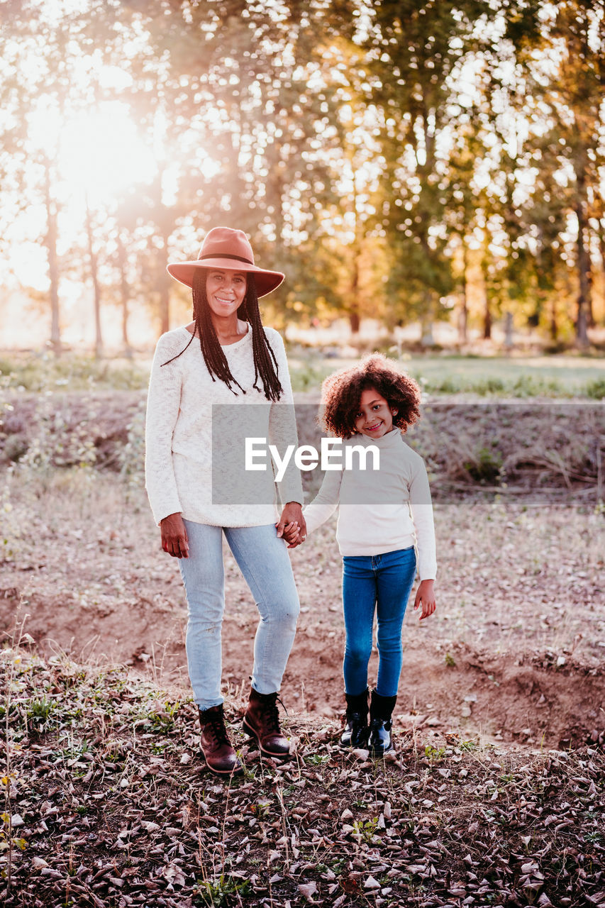 Full length of smiling woman standing on land