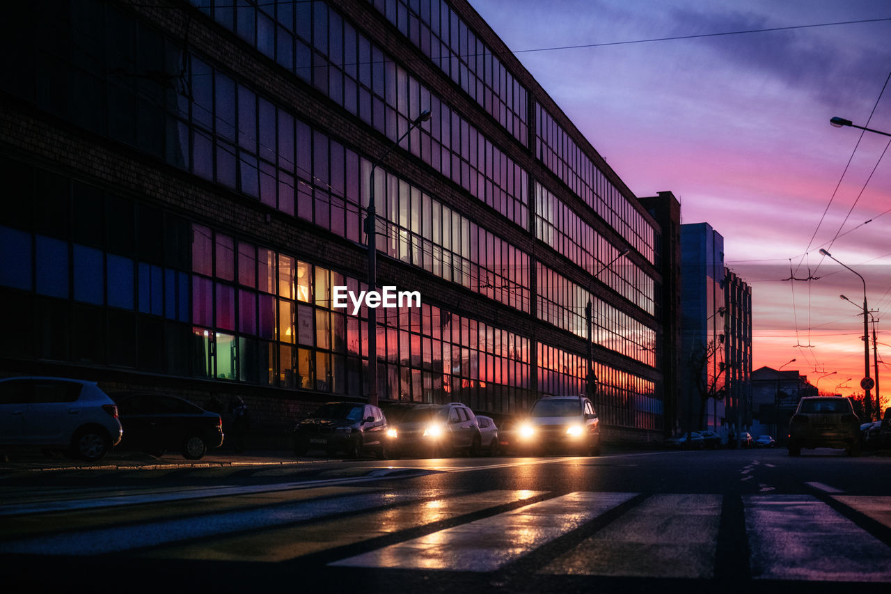 Cars on road in city during sunset