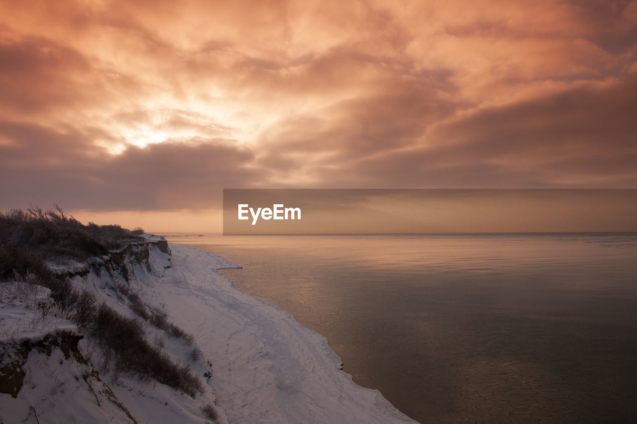 Snow-covered coast of baltic sea on peninsula fischland in germany with mystical light atmosphere