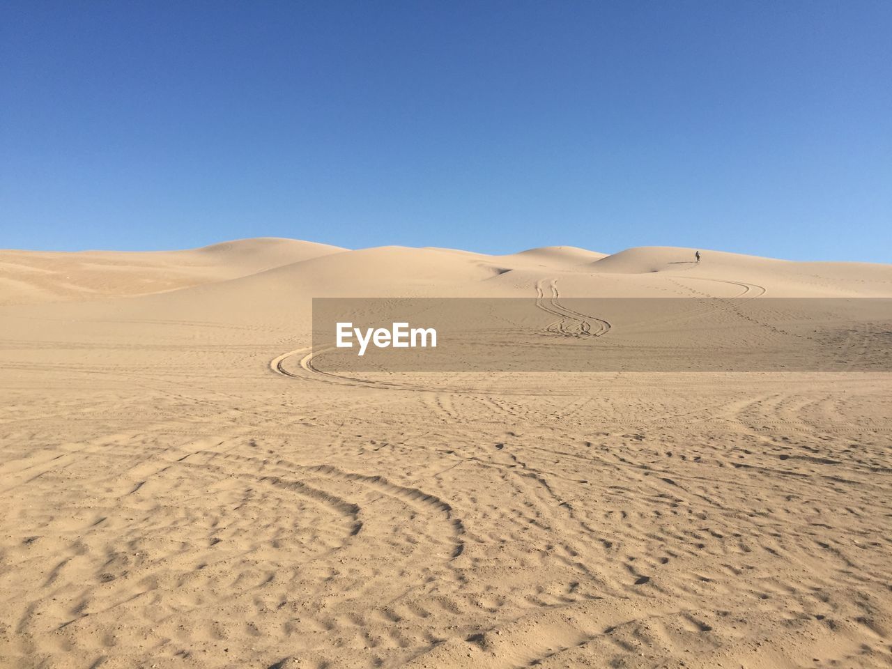 Scenic view of desert against clear blue sky