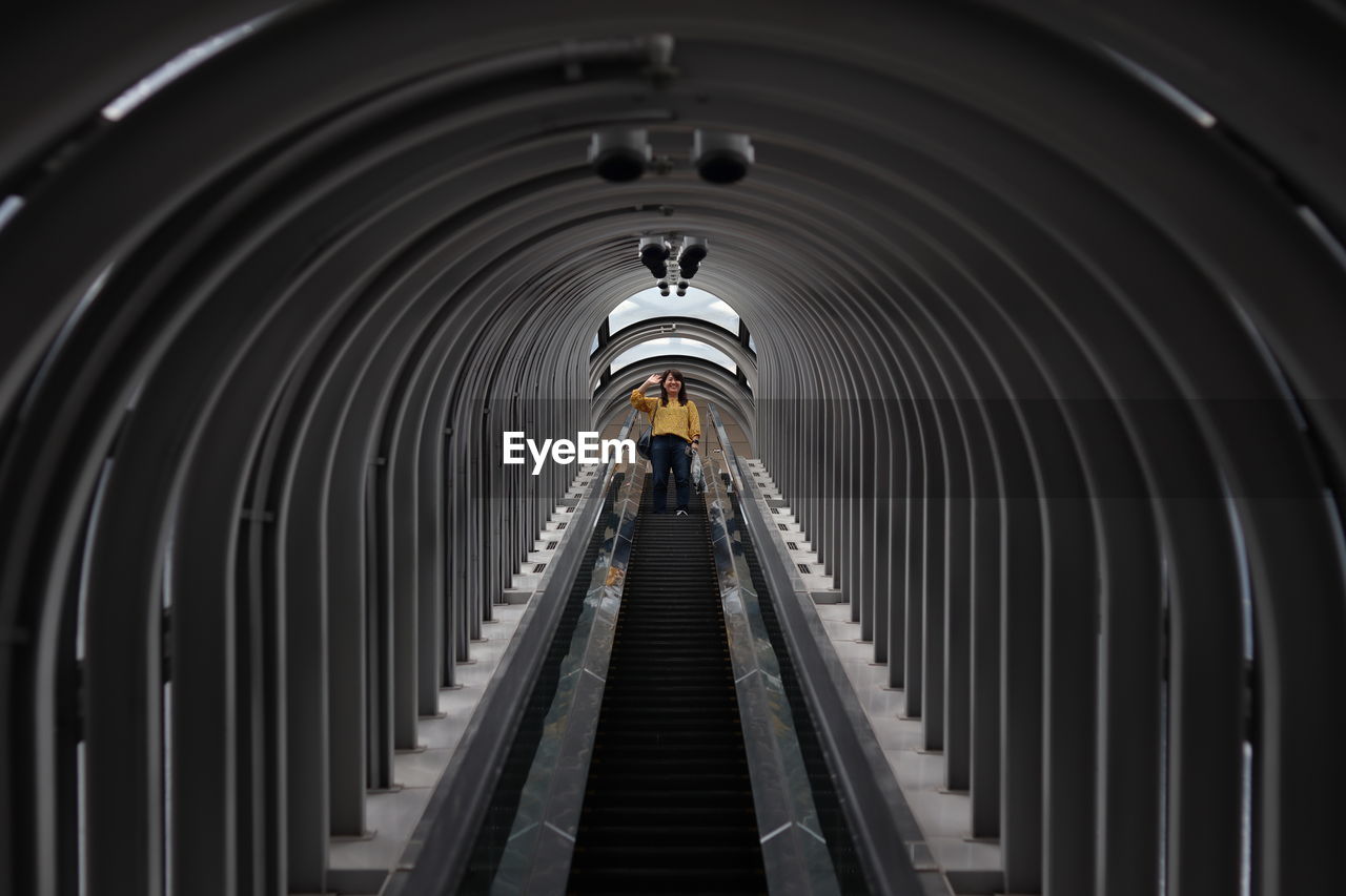 Low angle view of woman on escalator