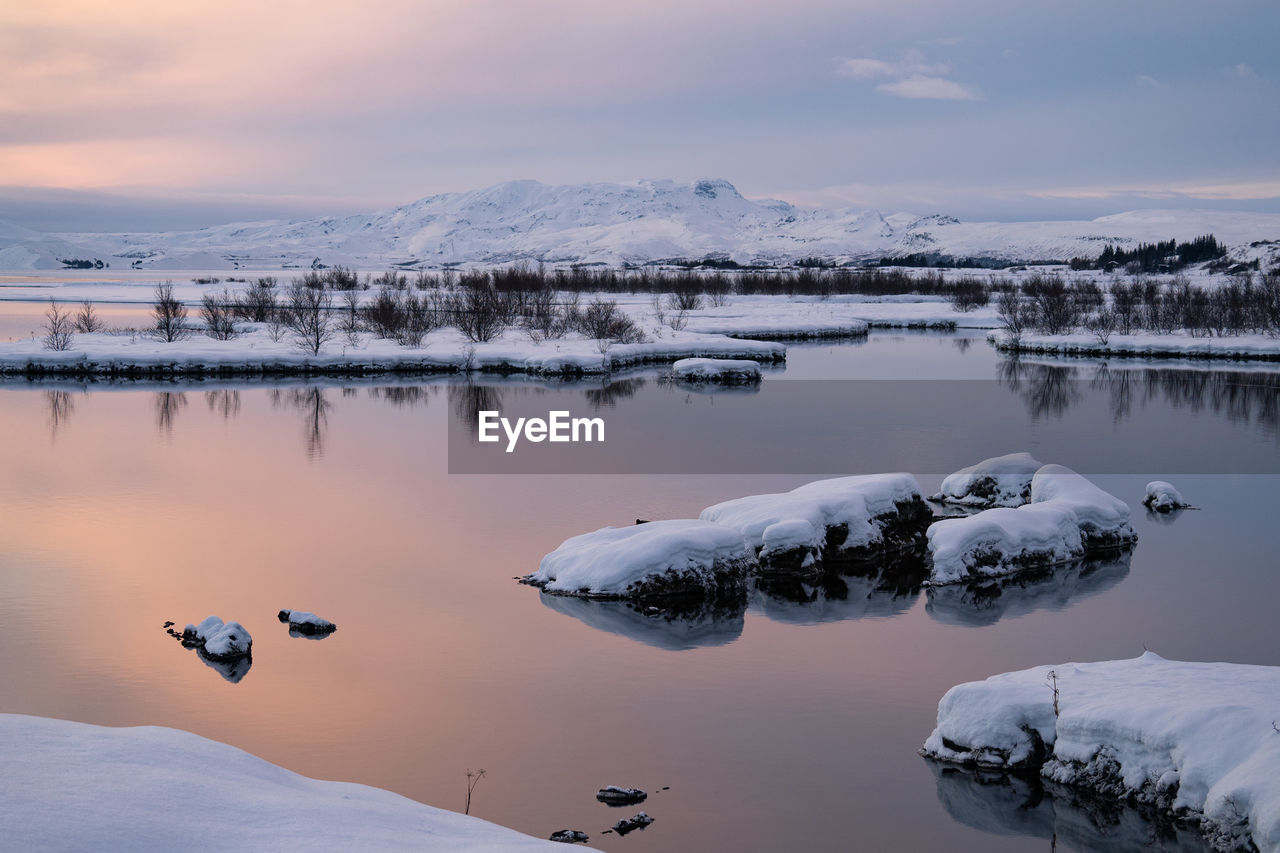 scenic view of lake against sky at sunset