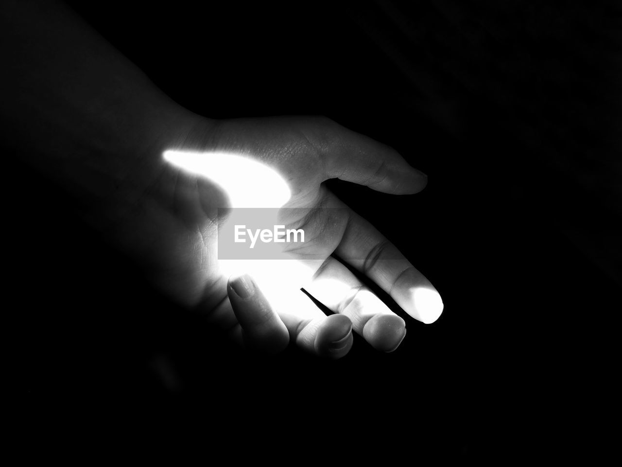 Cropped hand of person gesturing in darkroom