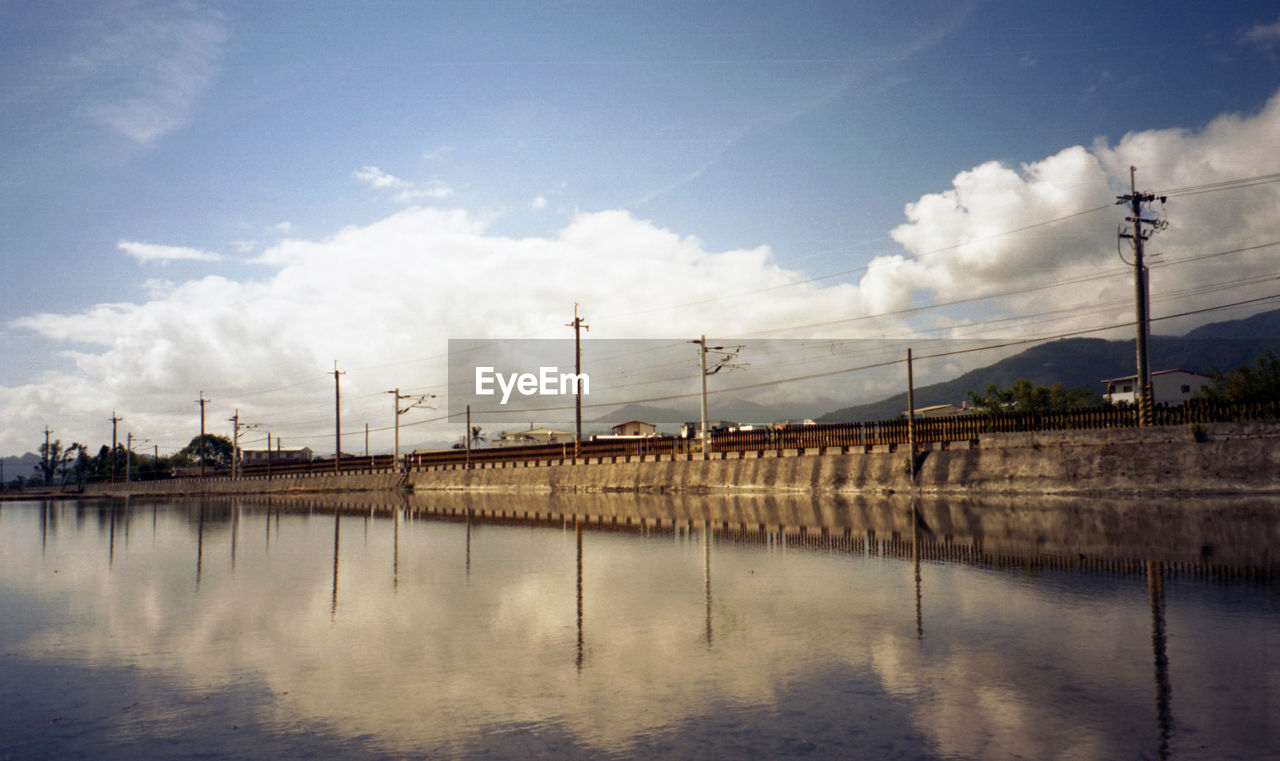 reflection, sky, water, cloud, morning, architecture, nature, built structure, river, dusk, electricity, power generation, no people, environment, bridge, technology, transportation, industry, outdoors, horizon, electricity pylon, waterway, cable, business finance and industry, day, building exterior, city, sunlight, blue, factory, beauty in nature