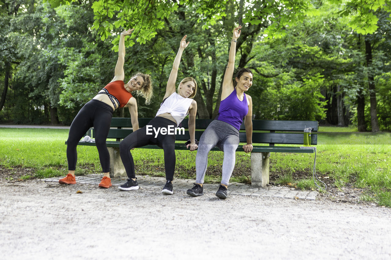 Three young ladies working out on a park bench in munich germany