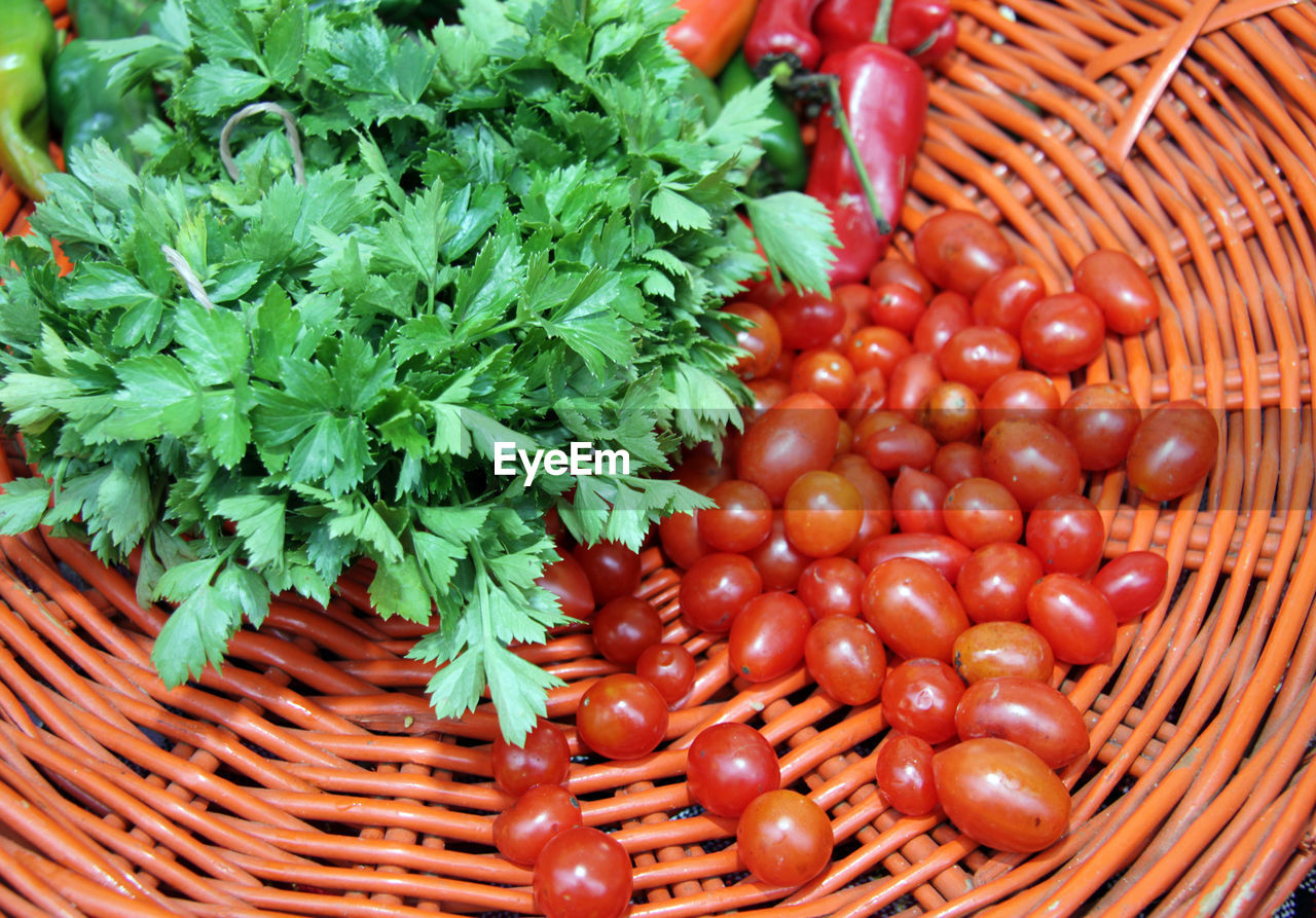 Parsley and cherry tomatoes in orange knitted basket