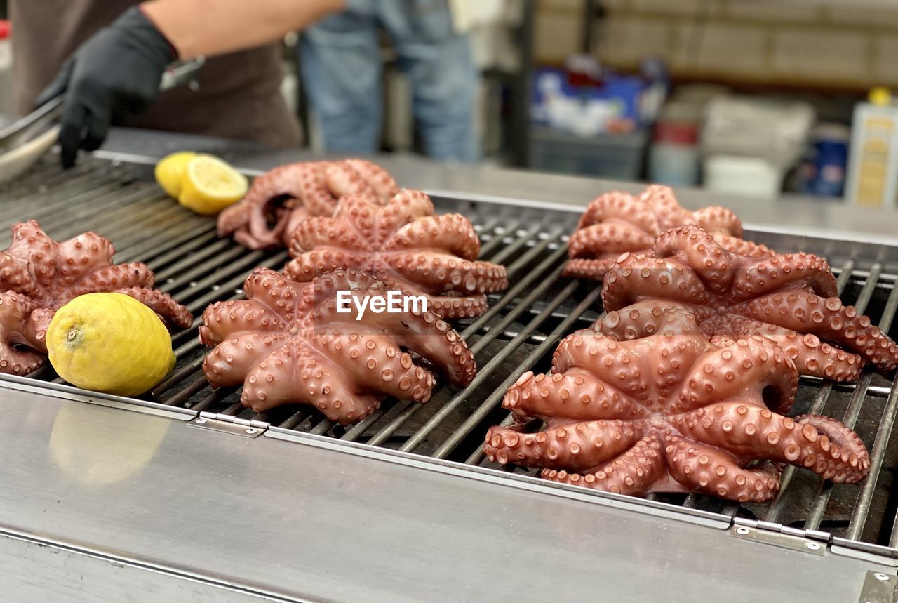 Cropped hand preparing grilled octopus 