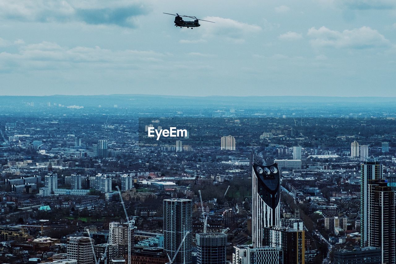 Aerial view of buildings in city against sky