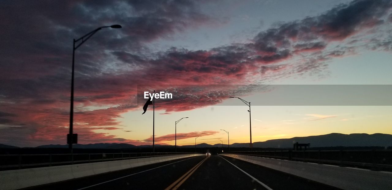 ROAD BY SILHOUETTE STREET AGAINST SKY DURING SUNSET