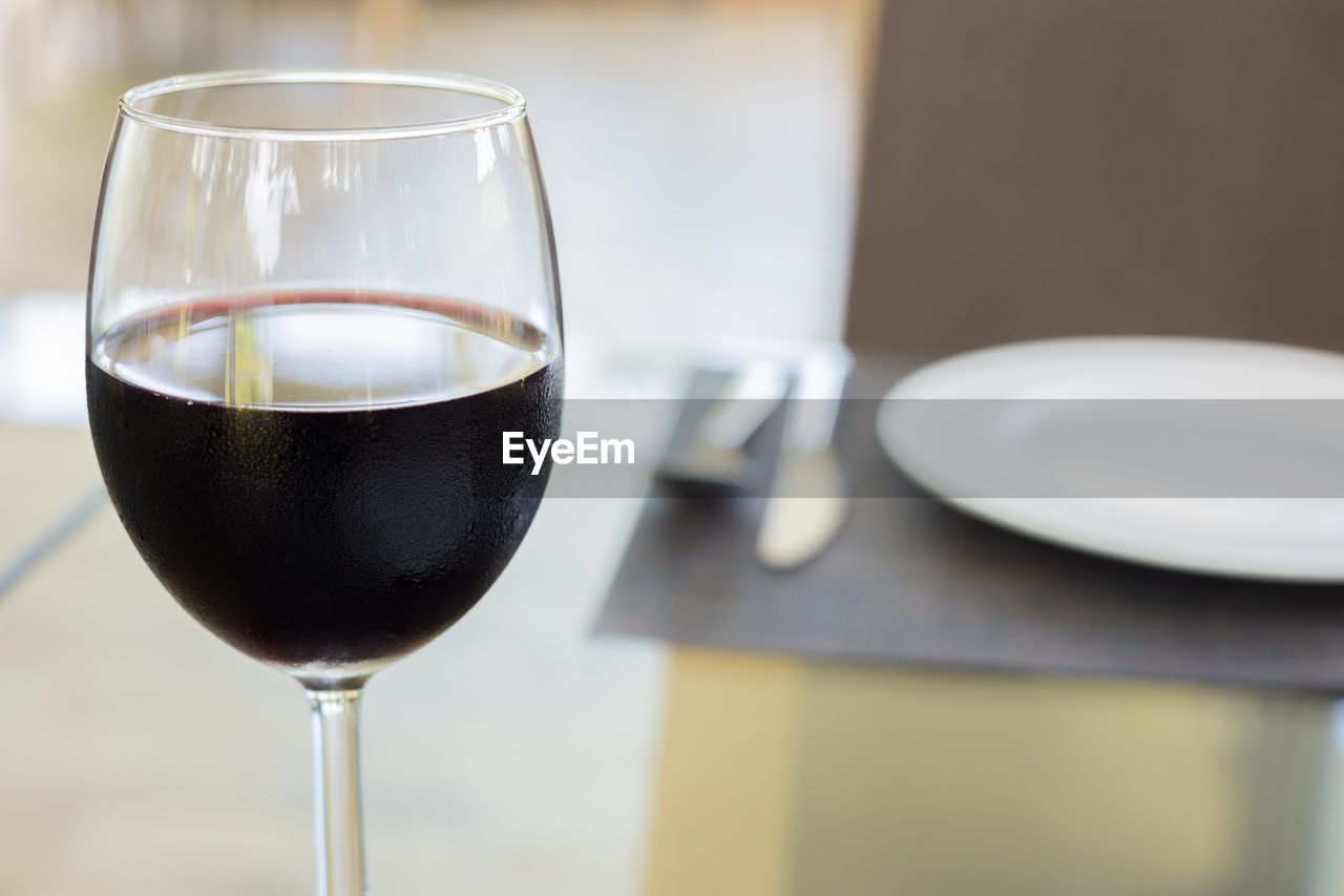 Selective focus and blurred background with copy space of glass of red wine with tableware  set 