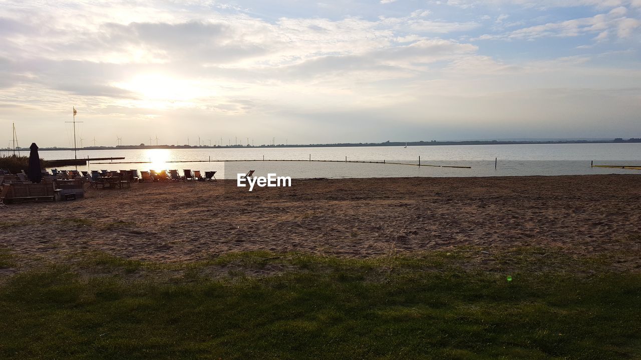 SCENIC VIEW OF BEACH AGAINST SKY DURING SUNSET