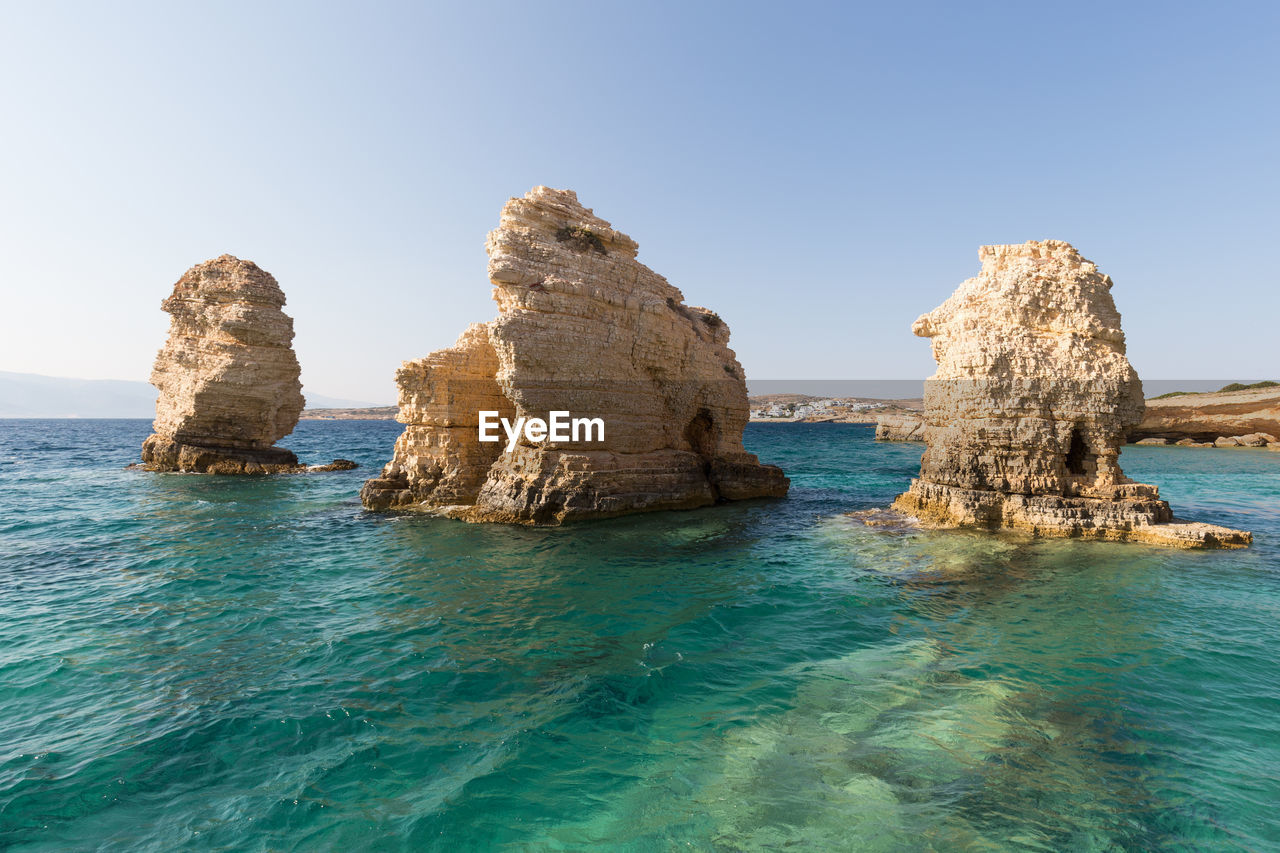 ROCK FORMATION IN SEA AGAINST CLEAR SKY