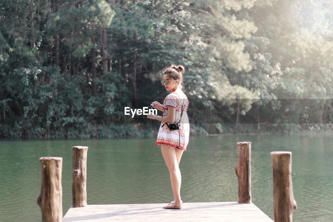 Full length of girl standing on pier over lake