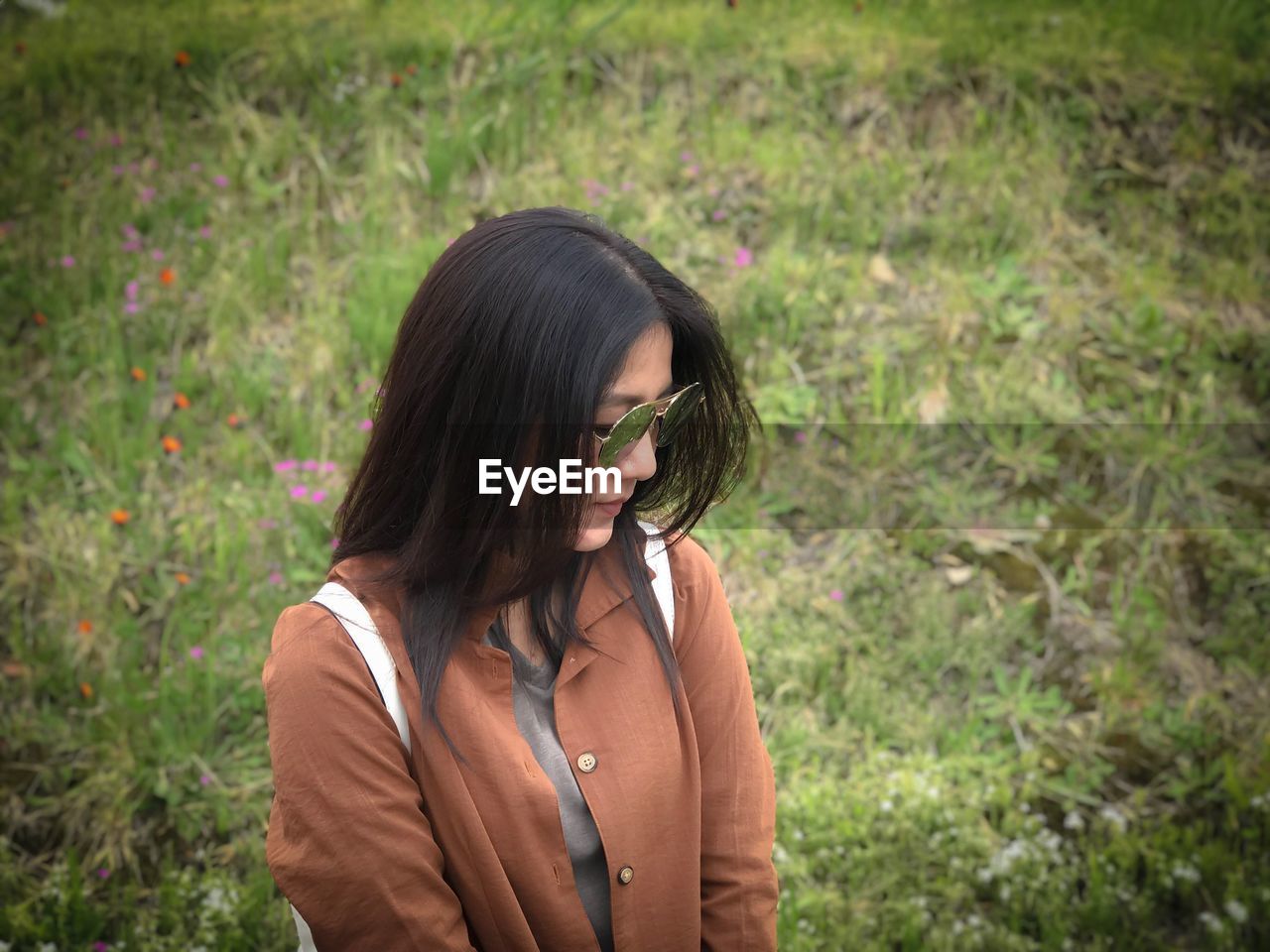 Woman wearing sunglasses while standing on field