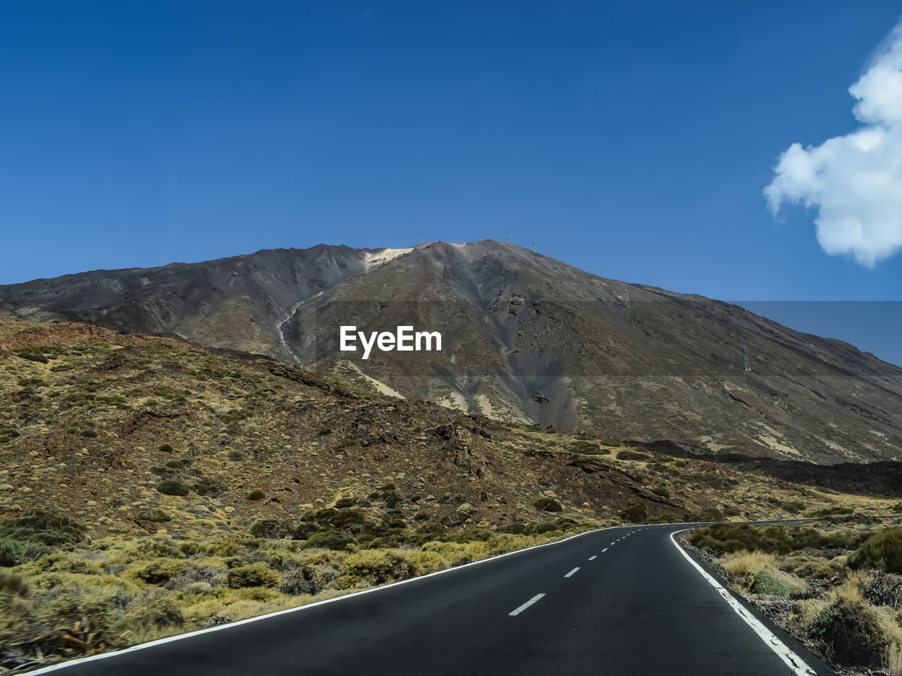 Road amidst mountains against blue sky