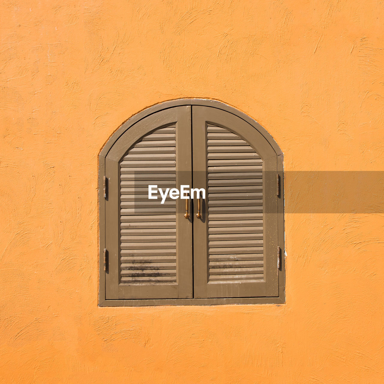 Close-up of window on orange wall