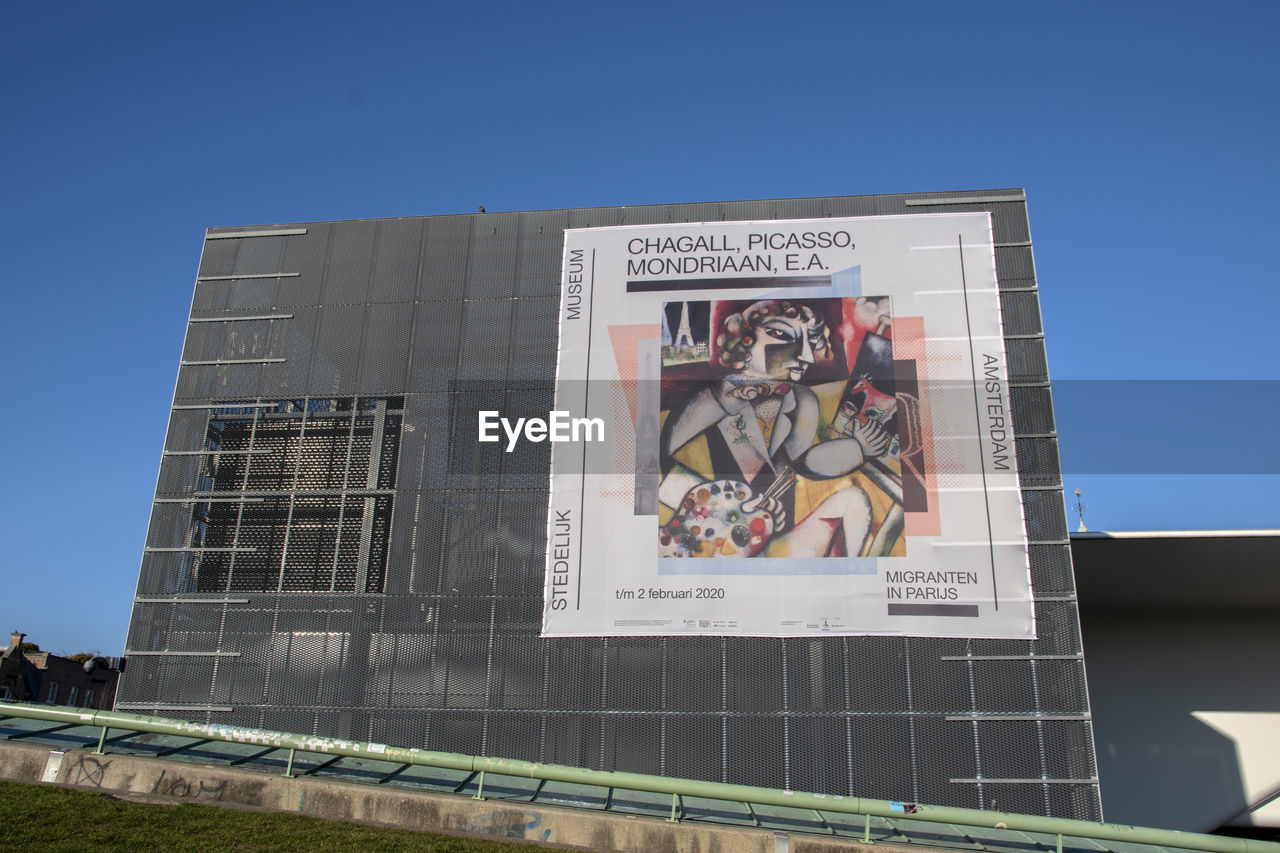 LOW ANGLE VIEW OF INFORMATION SIGN AGAINST BUILDING