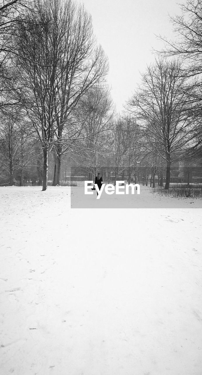 MAN ON SNOWY FIELD AGAINST SKY