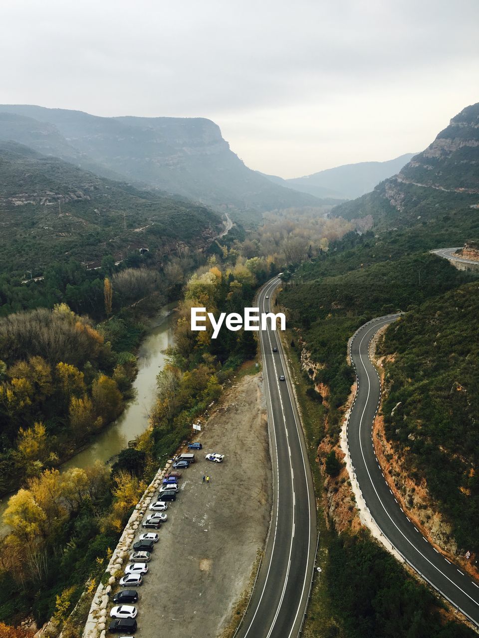 High angle view of cars parked on field by street