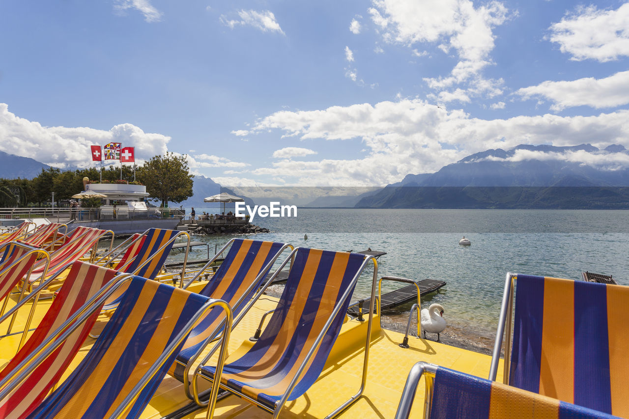 Switzerland, canton of vaud, vevey, empty deckchairs on shore of lake geneva