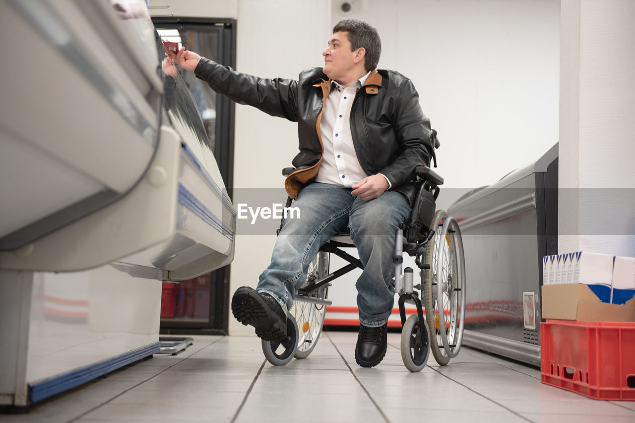 A disabled person in a wheelchair buys groceries